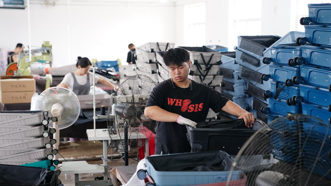 7月4日，工人在白溝新城鵬杰皮具有限公司生產(chǎn)車間忙生產(chǎn)、趕訂單。孫珞瑜攝